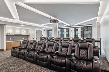 A row of black leather seats in a movie theater.